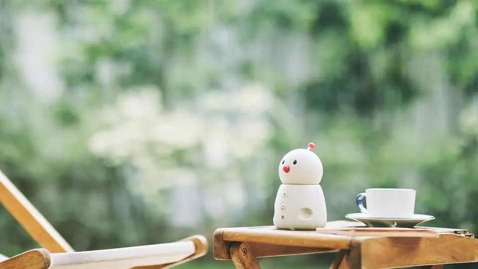 屋外のテーブルに置かれたファミリーロボット「BOCCO emo」