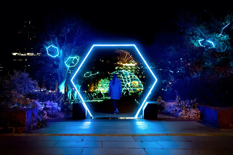 青く光る六角形のゲートをくぐる来場者。奥には「CROSS DOME」が見える