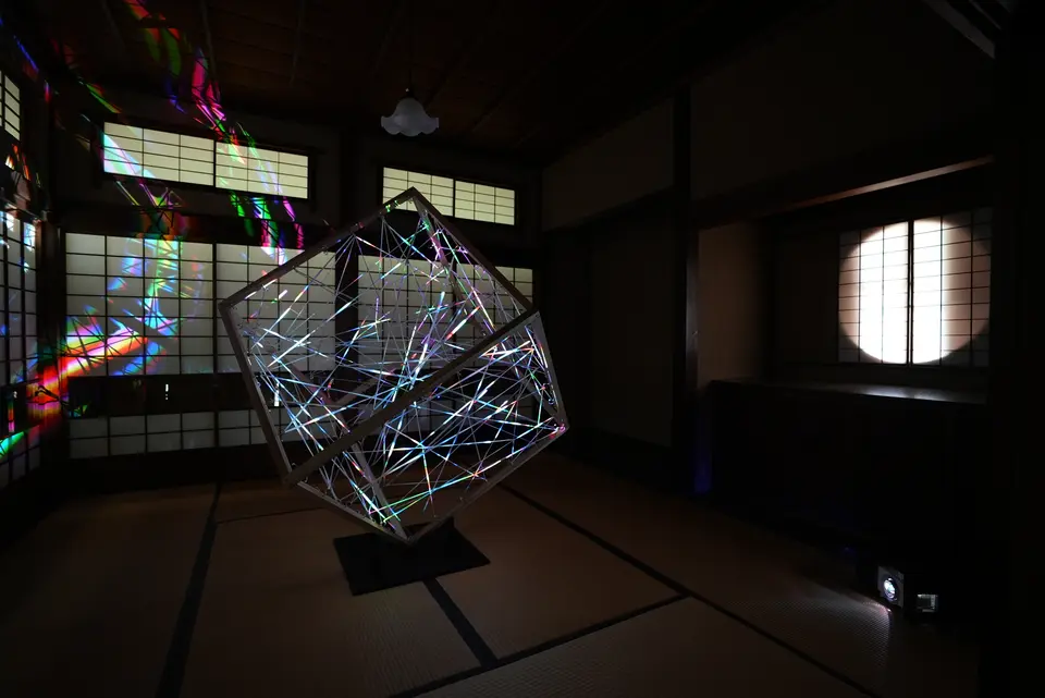 戸定邸の離座敷に設置された《layers》。木製の立方体に張った糸と、周囲の障子や天井に色のある光が広がる。
